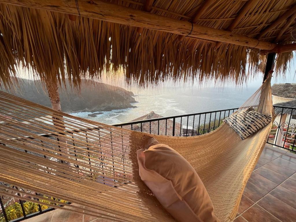 a hammock on a beach with a view of the ocean at Bungalow Kuaa in Puerto Ángel