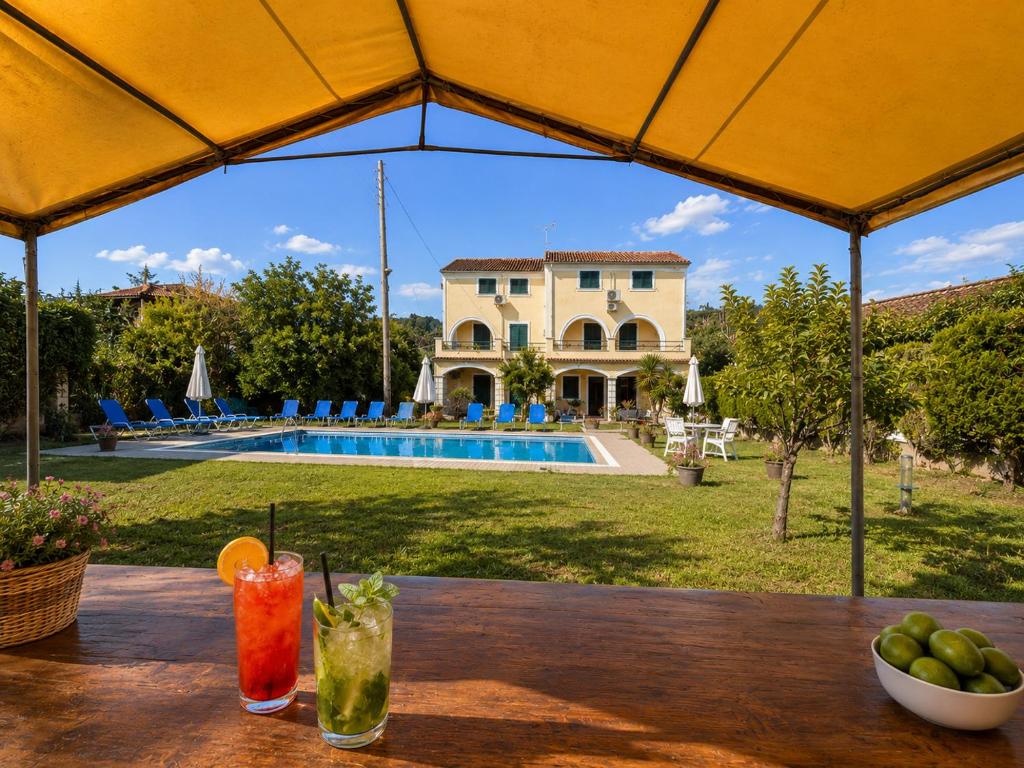 a table with drinks on it in front of a house at Pangea Corfu Villa in Sidari