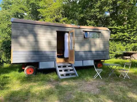 a small trailer sitting in the grass in a field at Roulotte in Huismes