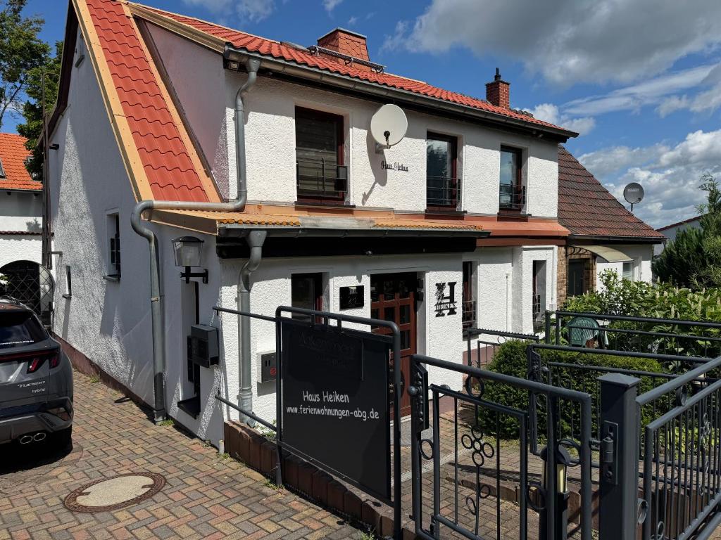 a white house with a sign in front of it at Haus Heiken Apartment Sonnenblume in Altenburg