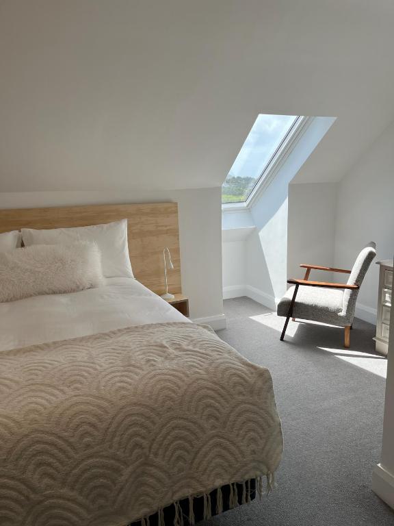 a bedroom with a bed and a chair and a window at Leac na Cille in Dingle