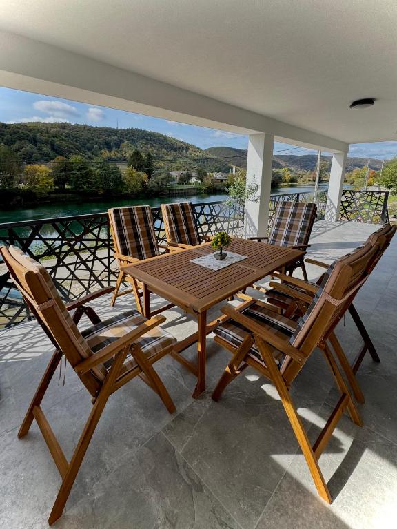 a wooden table and four chairs on a patio at Vila Kraljica Une in Bosanska Krupa