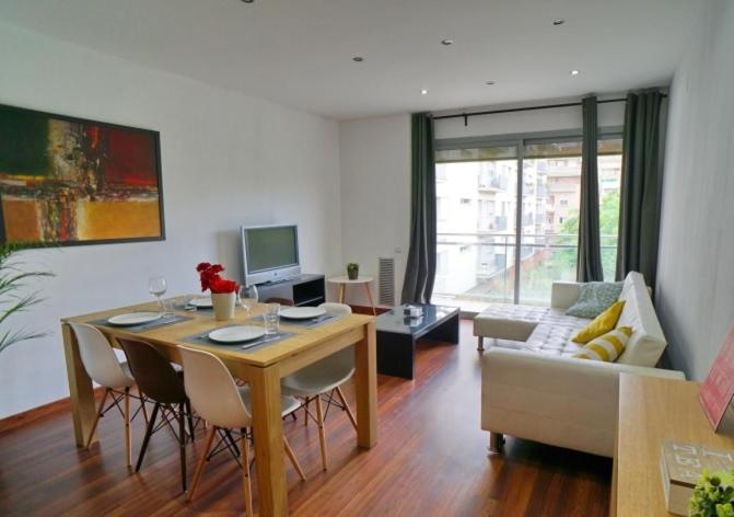 een woonkamer met een tafel en een bank bij Apartamento FIRA Barcelona in Hospitalet de Llobregat
