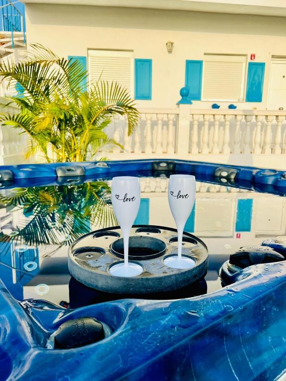 two wine glasses sitting on top of a table at Typical Canarian House private jacuzzi, sauna, gym, Finca Conejo Taucho Adeje by Aqua Vista Tenerife in Adeje