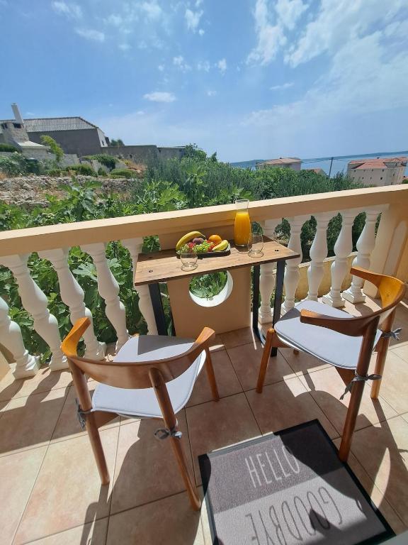 a balcony with a table and chairs on a balcony at Olivus 3 in Miletići
