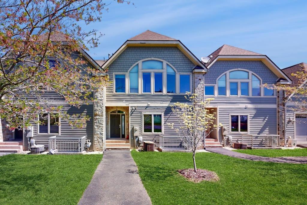 a house with blue windows and a tree in the yard at Amazing Overlook in McHenry