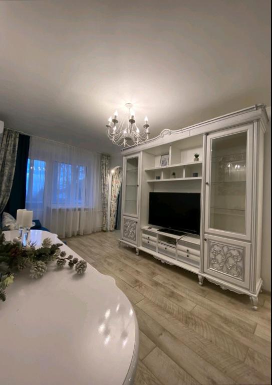 a living room with a television and a white entertainment center at Центр Пассаж ЦУМ in Dnipro