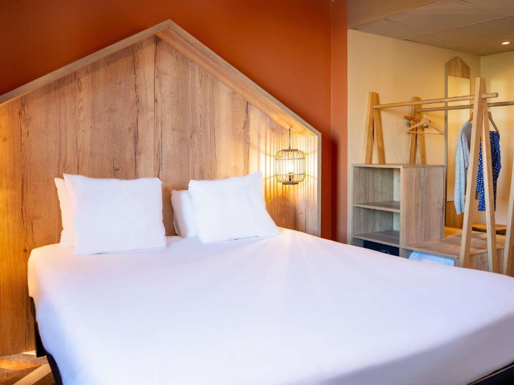 a large bed with two pillows in a room at ibis Styles Chatenay Malabry Paris Sud in Châtenay-Malabry