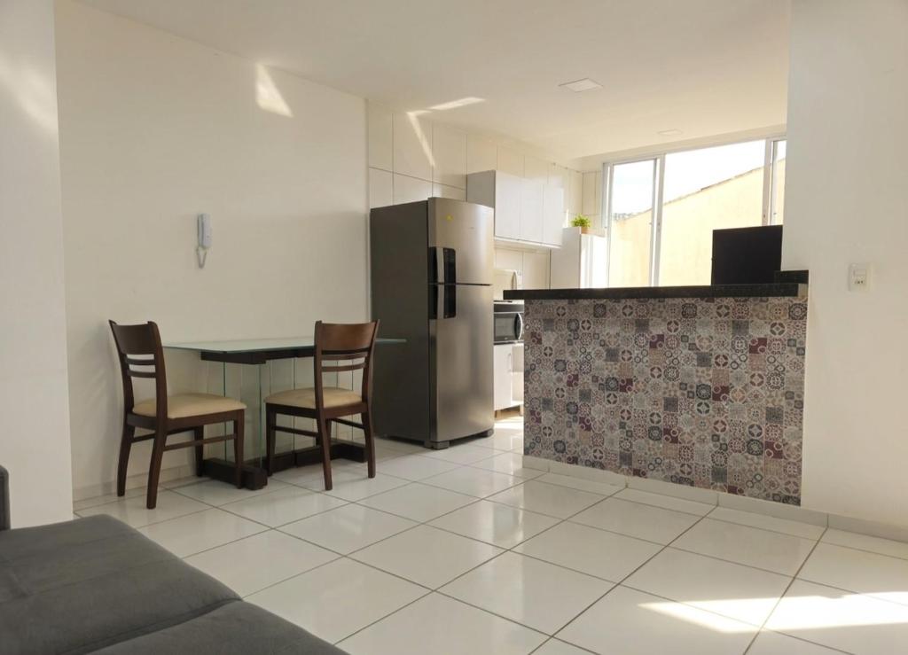 a kitchen with a table and chairs and a refrigerator at Apartamento Moto Chico Petrolina in Petrolina