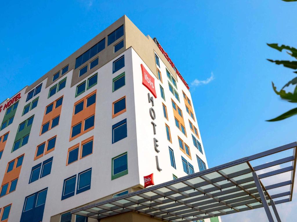 a tall white building with a sign on it at ibis Bengaluru Hebbal - An Accor Brand in Bangalore