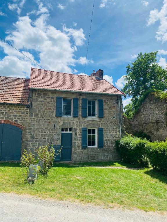 a stone house with blue shutters and a yard at Gîte La Vie Verte - Gîte charmant 3 etoiles classé Meublé de Tourisme in Saint-Domet
