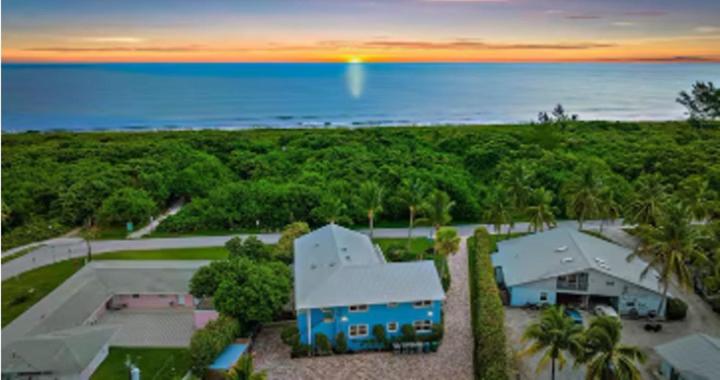 an aerial view of a blue house with the ocean at Dual En-Suite Corner Unit - Sunrise Views in Fort Pierce