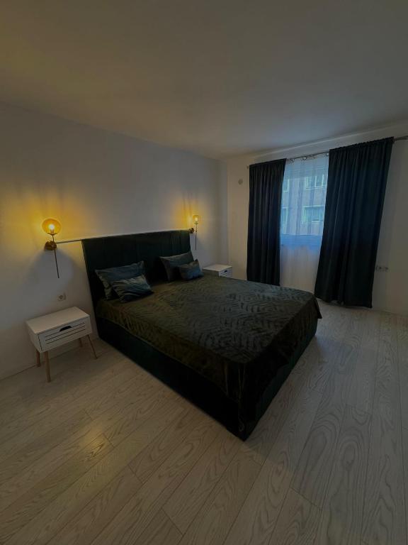 a bedroom with a large bed and a large window at Apartament Deluxe in Orăştie