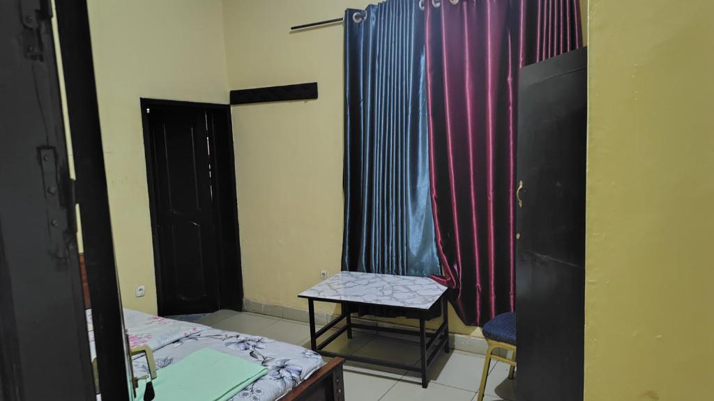 a room with a table and a chair and a curtain at Life Vision Hotel in Huye