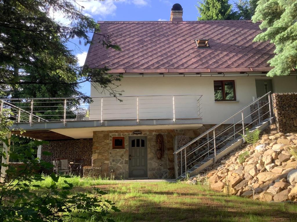 a house with a metal roof and a balcony at Chata Vedle Jedle in Dolní Morava