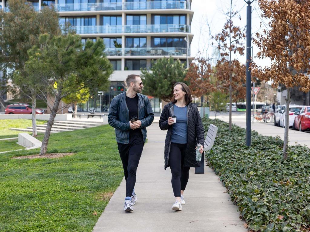 a man and a woman walking down a sidewalk at The Sebel Canberra Campbell in Canberra