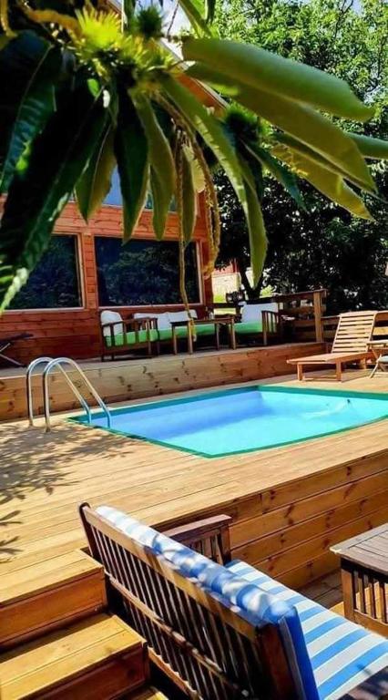 a pool on a wooden deck with chairs and a table at Kedra Village Retreats - Mountain Escape in Mastoréïka