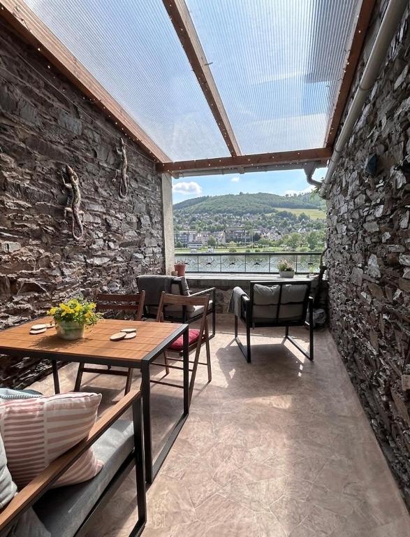 a patio with a table and chairs and a window at Ferienwohnung Moselblick in Alf