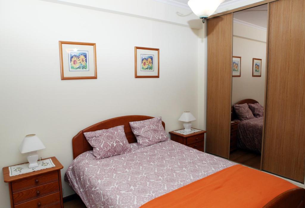 ポンタ・デルガダにあるJP Alojamento Localのベッドルーム(ベッド1台、鏡付)