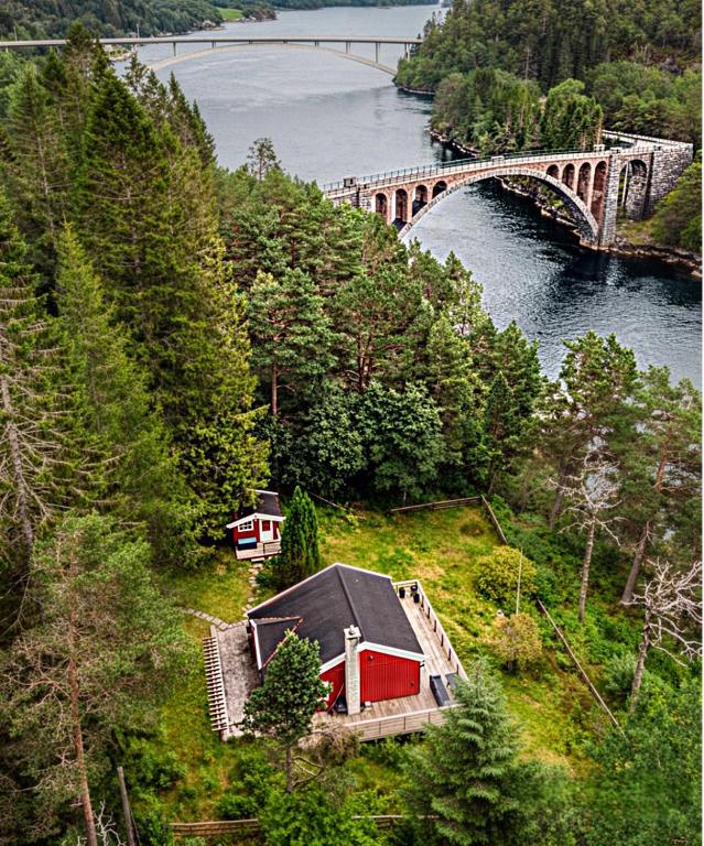 a house on a hill next to a bridge at Forest Cabin by the Water in Ålesund