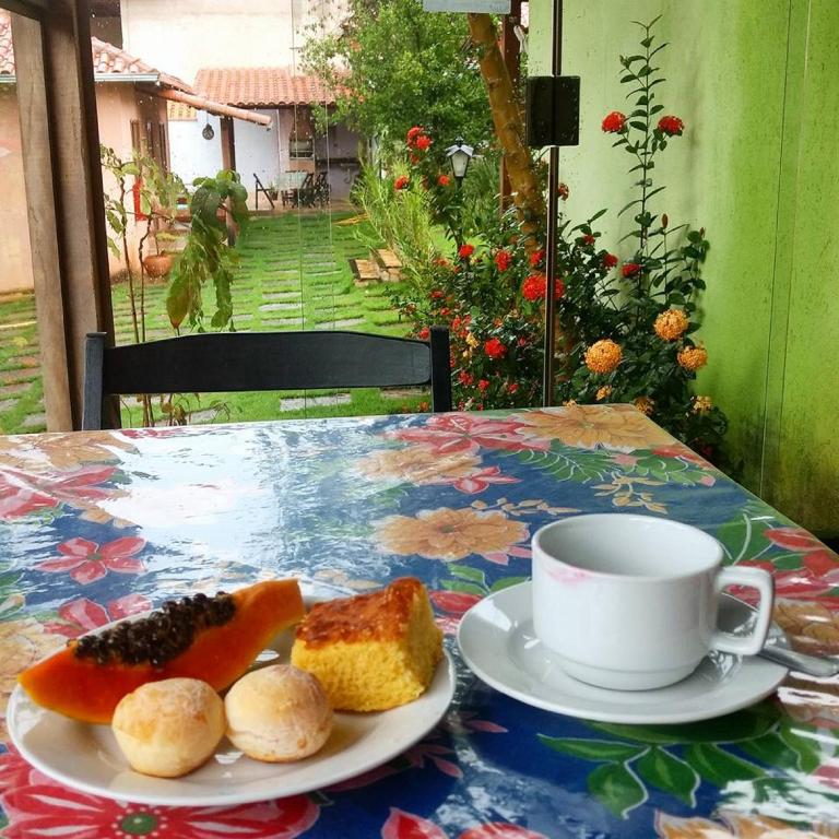a table with a plate of food and a cup of coffee at Pousada Licuri in Serra do Cipo