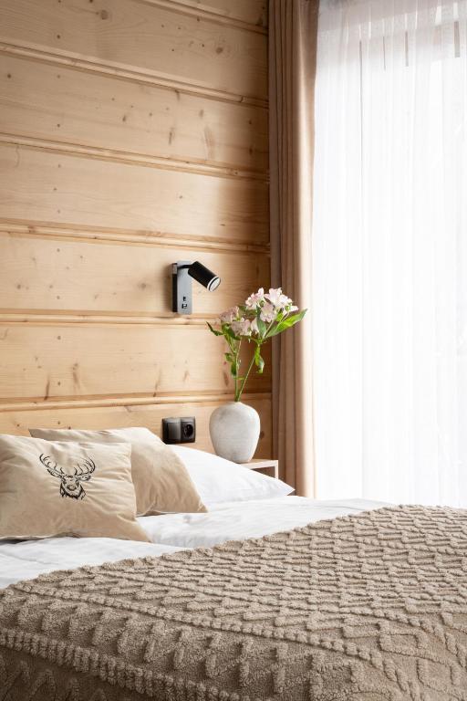 a bedroom with a bed and a vase with flowers at Willa Lasak - 20 procent zniżki na Termy, Śniadania in Biały Dunajec