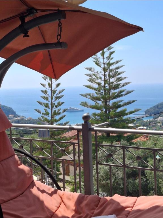 an umbrella sitting on a balcony with a view of the ocean at Elena Rista Studios in Parga