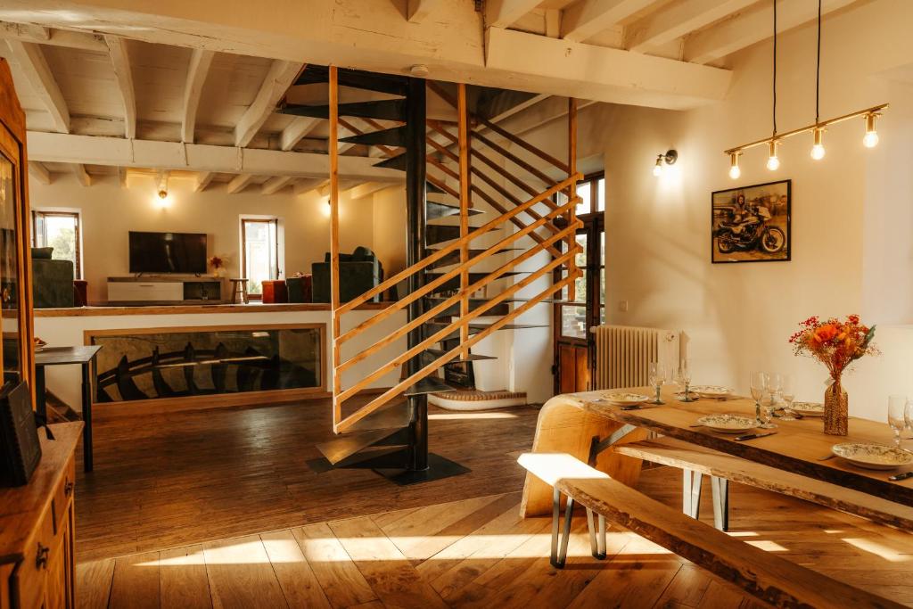 a living room with a staircase and a table at Moulin de Micheline - Jacuzzi - Vue Exceptionnelle in Bourg-dʼIré
