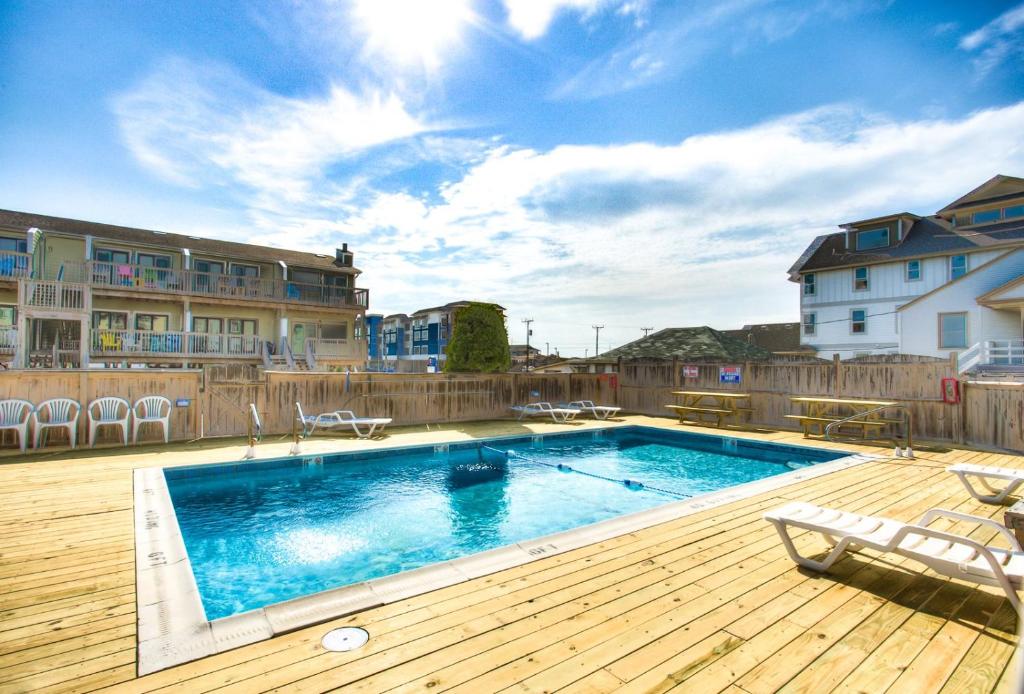 a swimming pool on a wooden deck next to a building at SW6 - Seawalk 6 in Kill Devil Hills