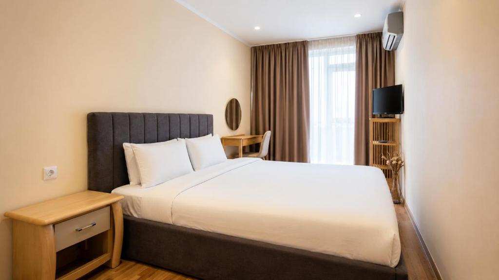 a hotel room with a bed and a window at Boris Garden Comfort Suite in Burgas