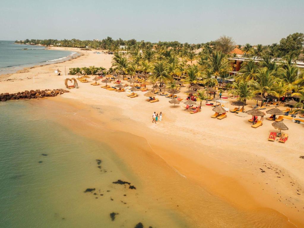 an overhead view of a beach with chairs and umbrellas at Movenpick Resort Lamantin Saly in Saly Portudal