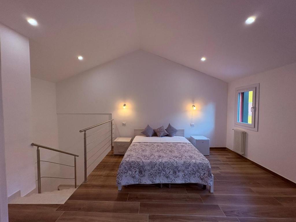 a bedroom with a bed in a white room at Casa Gina in Chioggia