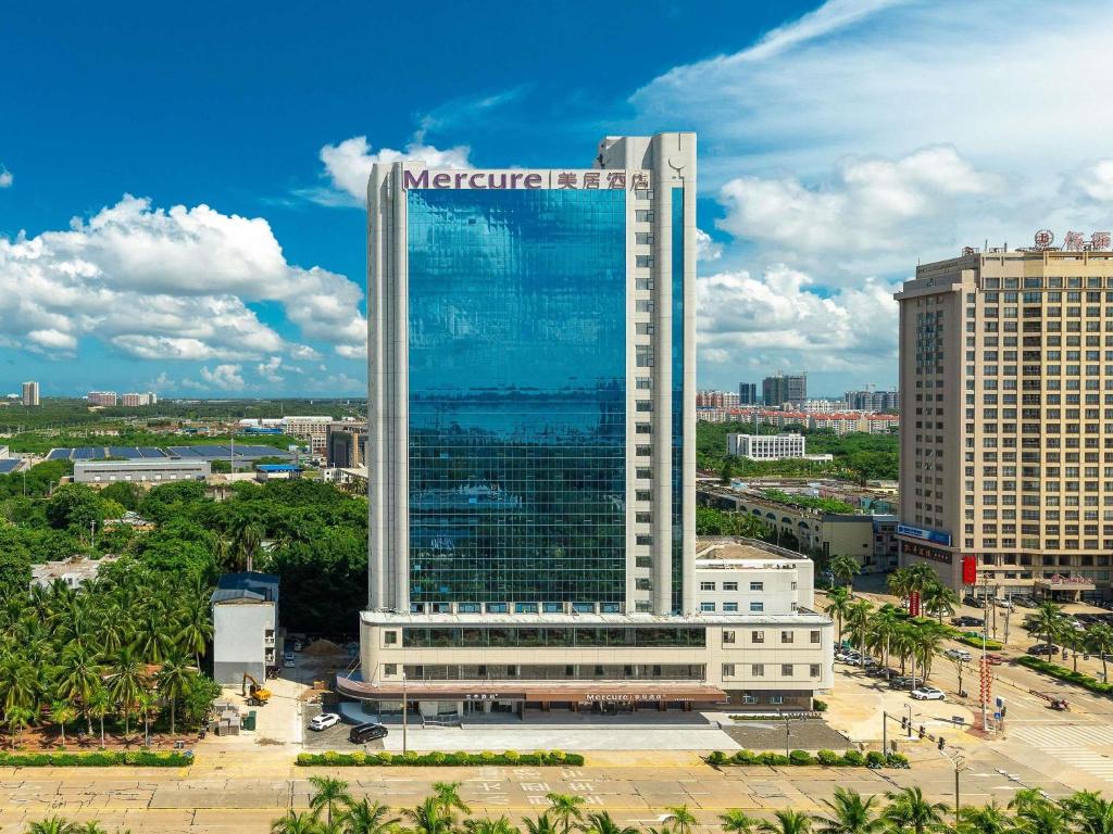 a large building with a sign on it in a city at Mercure Danzhou Yangpu Seaview in Dongshan