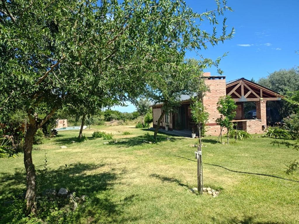 a house in the middle of a yard with trees at Al pie de la Sierra in Pueblito