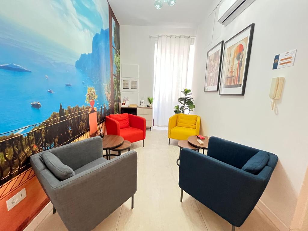 a living room with chairs and a painting on the wall at Four Points Suites in Naples