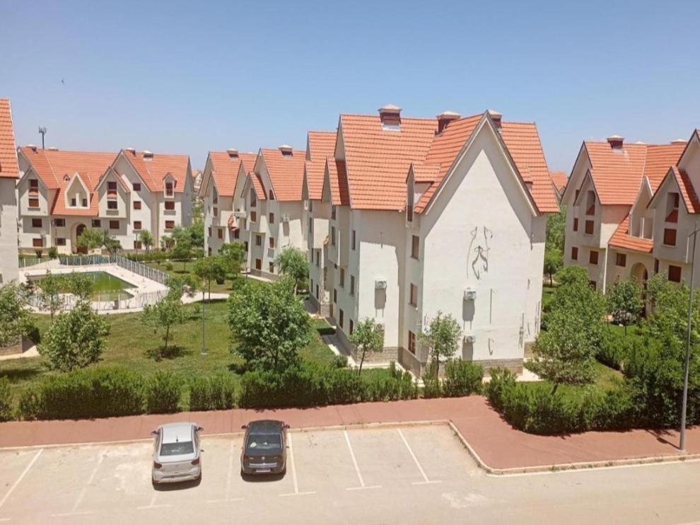 a row of houses with cars parked in a parking lot at Rez de chaussée in Ifrane