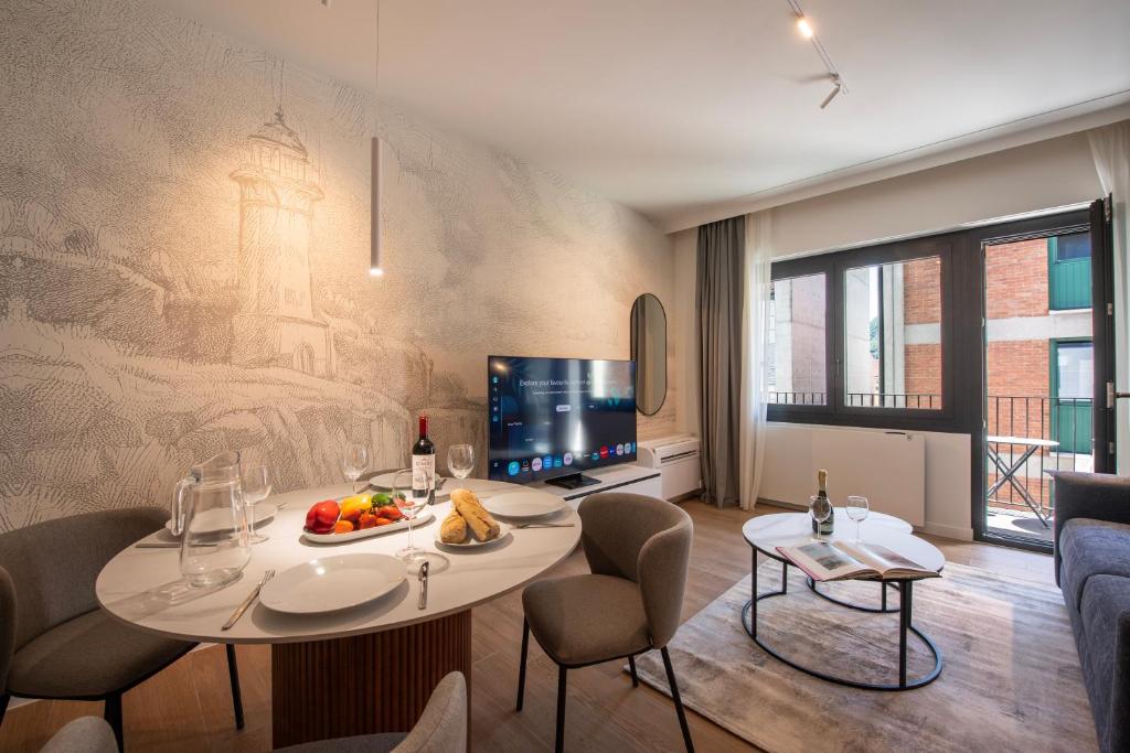 a living room with a table and chairs and a tv at Boutique Suites in Lugano