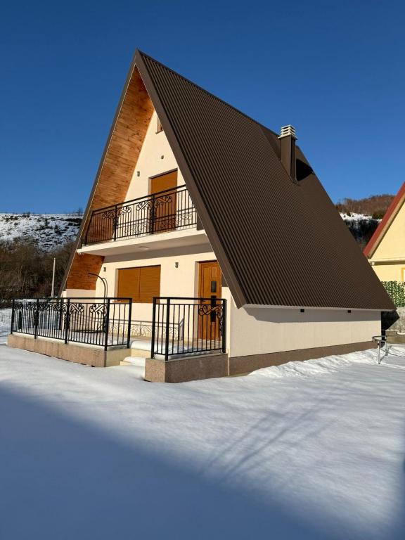 a house with a black roof in the snow at Veruša - Maksim's house in Veruša