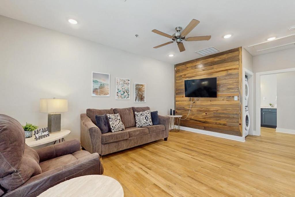 a living room with two couches and a flat screen tv at Gone Coastal Cottage in Rockport