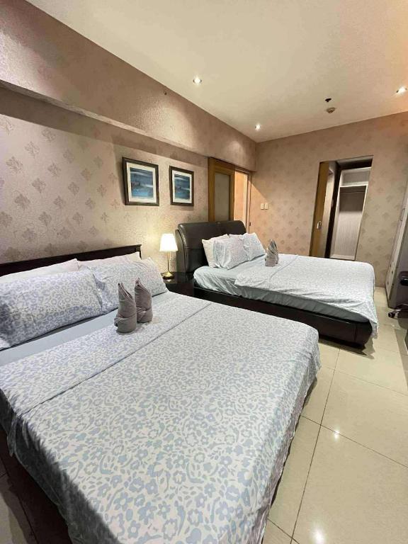 a hotel room with two beds with white sheets at Shell Residence Pasay City in Manila
