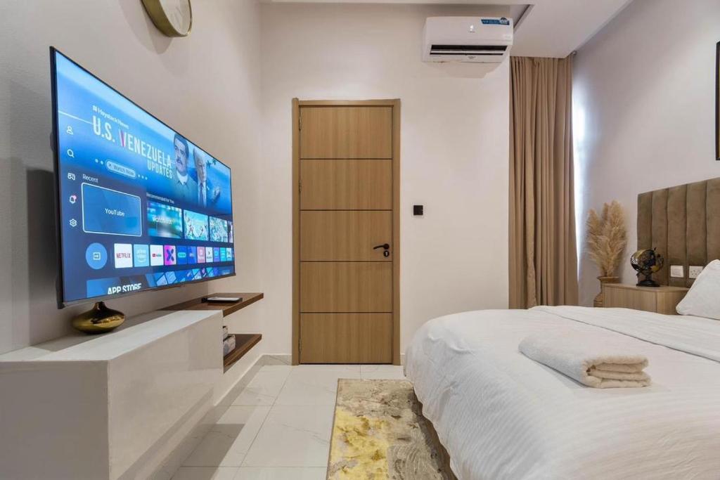 a bedroom with a large flat screen tv on the wall at Lisa homes 2 3bedroom in Lekki