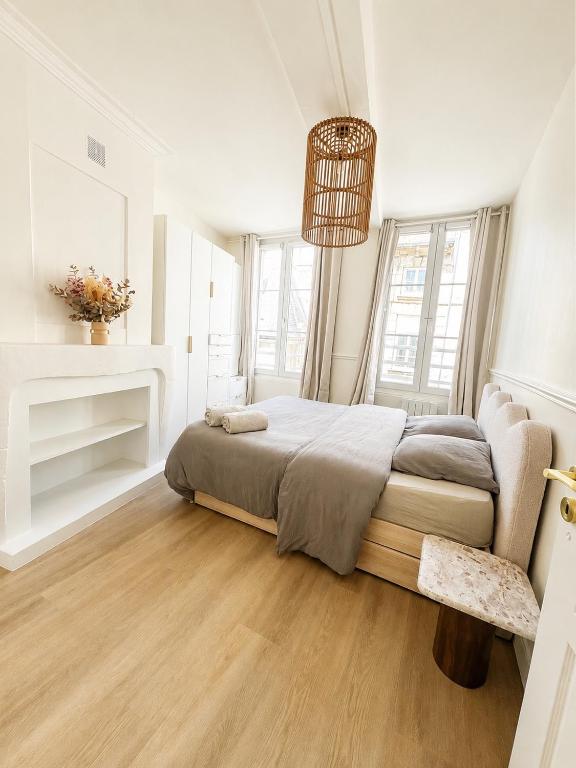 a white bedroom with a bed and a fireplace at Appartement hyper centre de Caen, refait à neuf, cosy in Caen