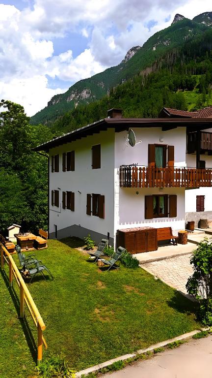 a white building with a balcony and a yard at Ciasa Civetta in Piaia