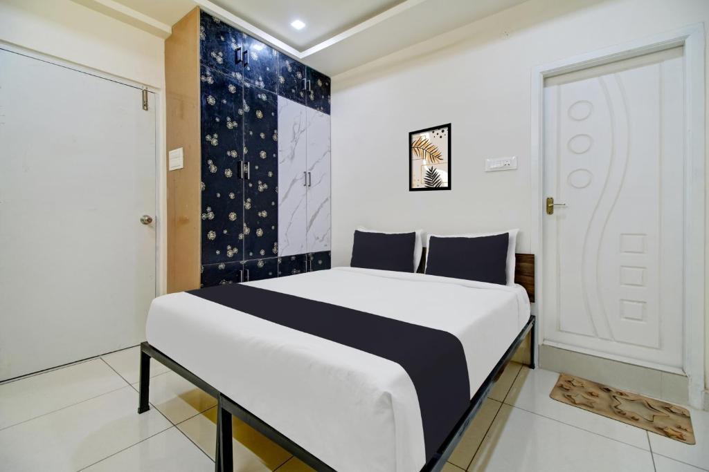 a bedroom with a bed in a room with a door at OYO Hotel O Amaravathi Road Annapurna Nagar in Guntūr
