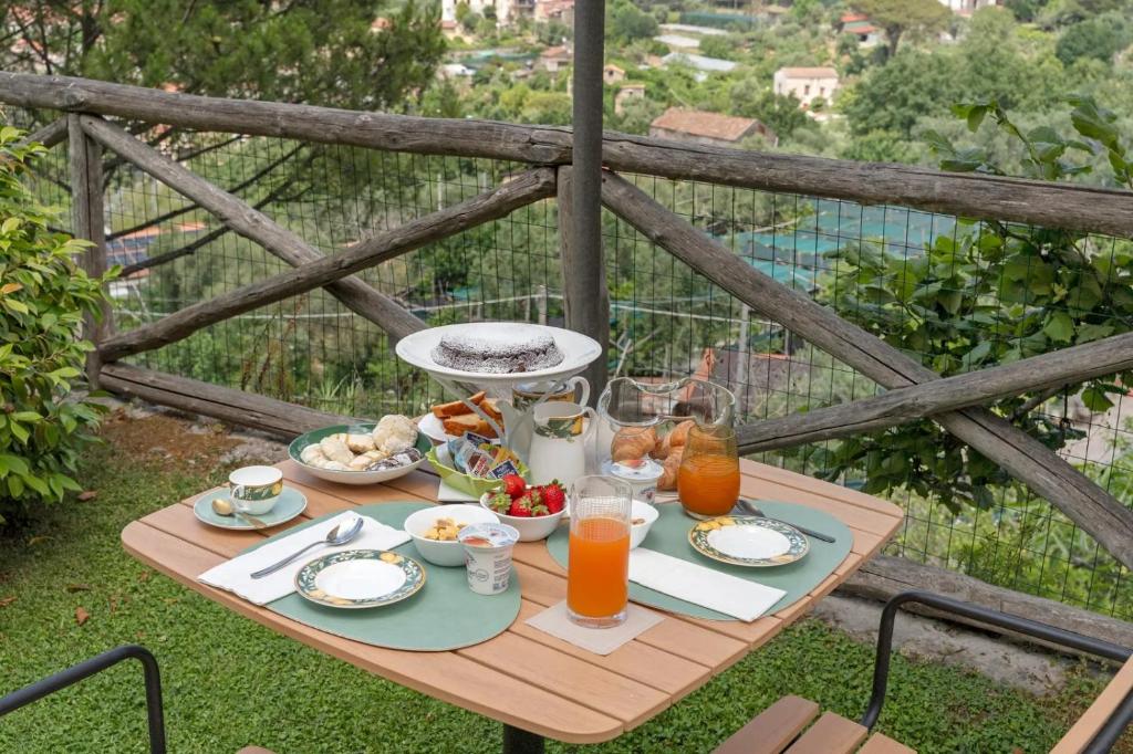 a table with breakfast food and orange juice on a balcony at Villevieille in Piano di Sorrento
