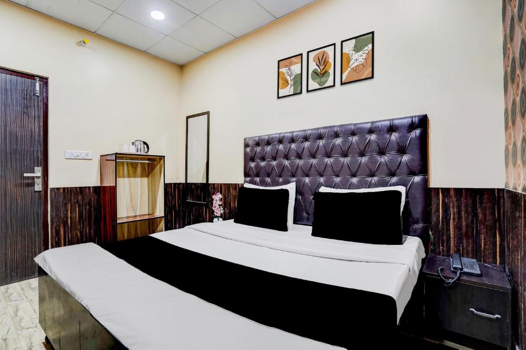 ein Schlafzimmer mit einem großen Bett mit Lederkopfteil in der Unterkunft Collection O by OYO Burlton Park Jalandhar Formerly Hotel R1 Inn in Jalandhar
