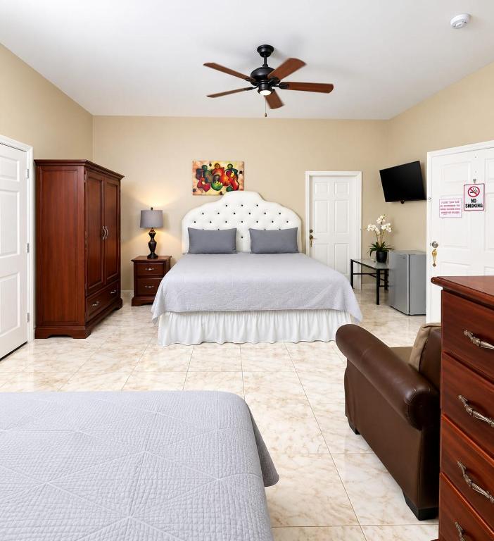 a bedroom with a bed and a ceiling fan at dela-de rose guesthouse in Negril