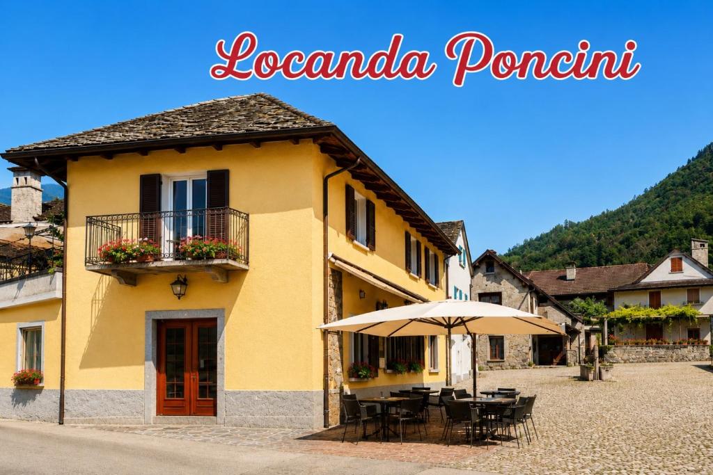 a yellow building with tables and an umbrella at Locanda Poncini in Maggia