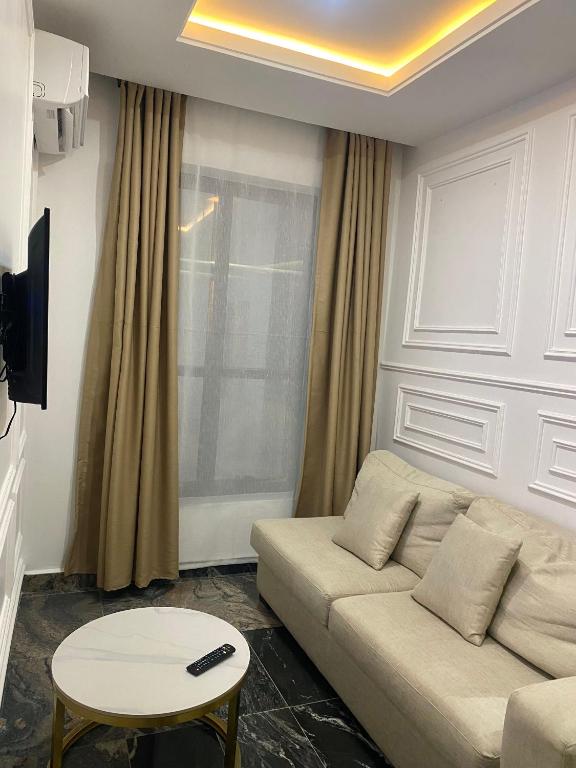 a living room with a couch and a table at Sennet Luxury Hotel in Uyo