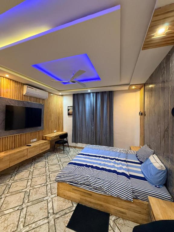 a hotel room with a bed and a tv at RAWADE Guesthouse in Cotonou